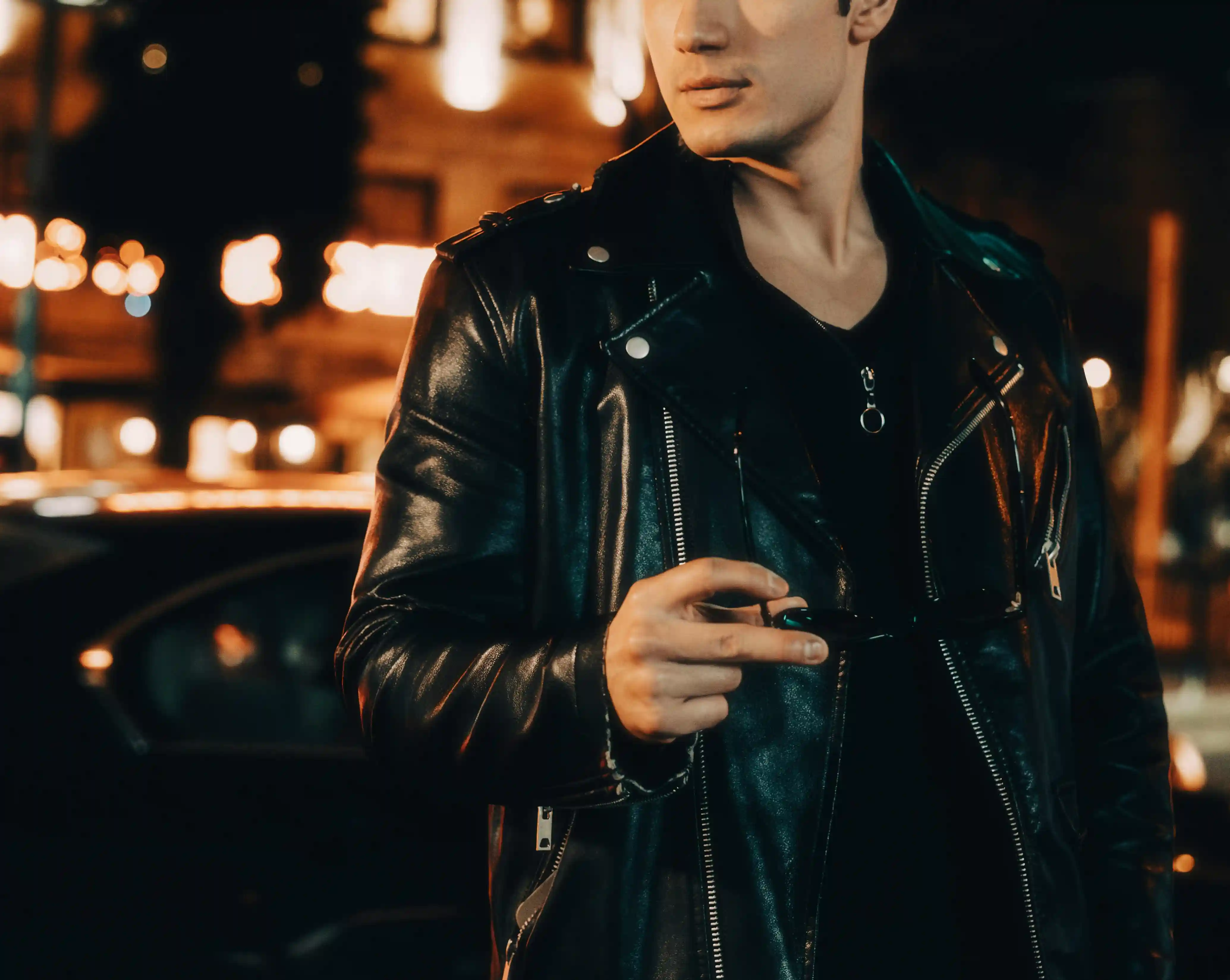 A man wearing a black shirt under a black leather jacket for cool date nights