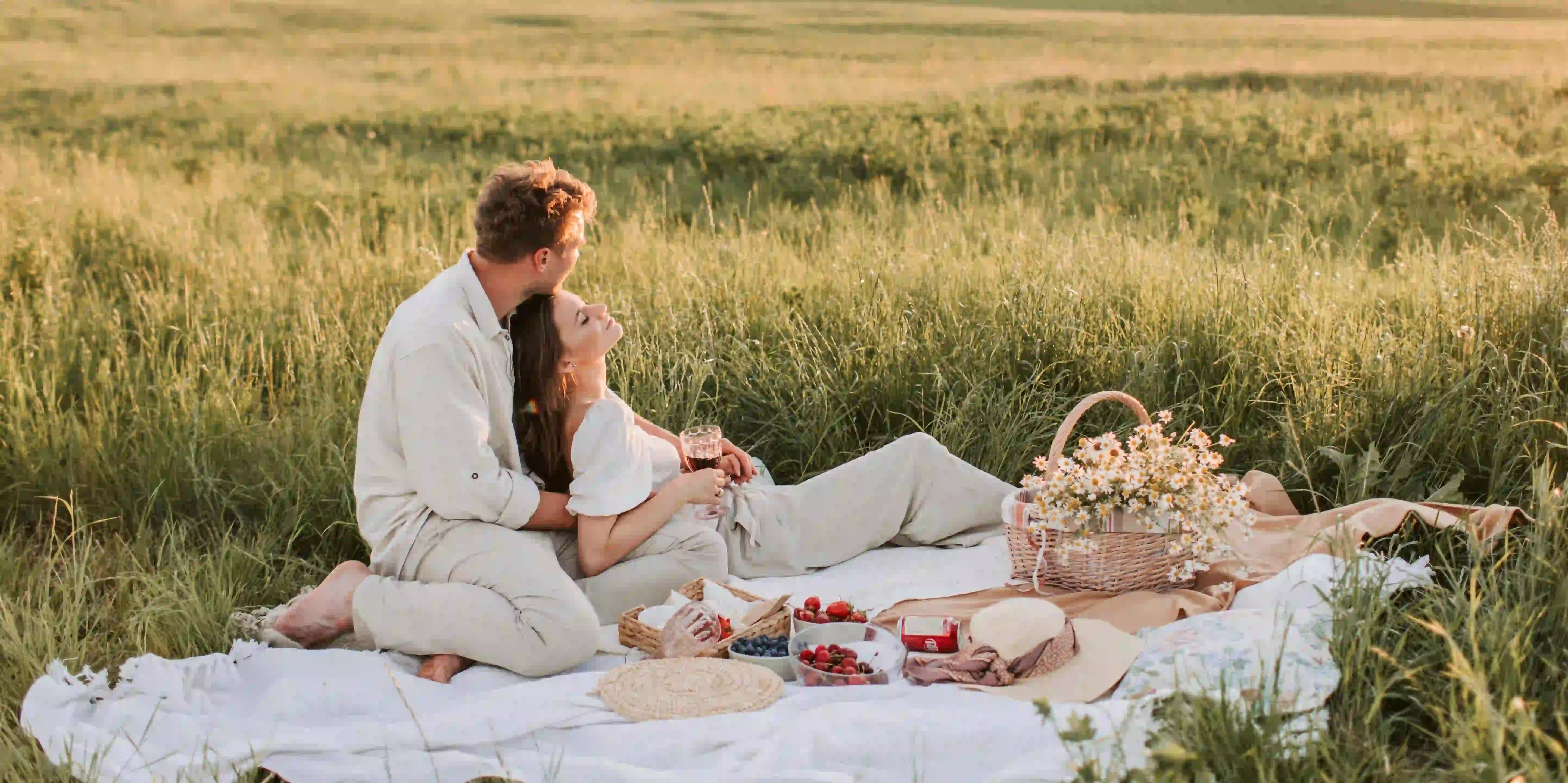 A couple having a picnic date in the middle of a meadow