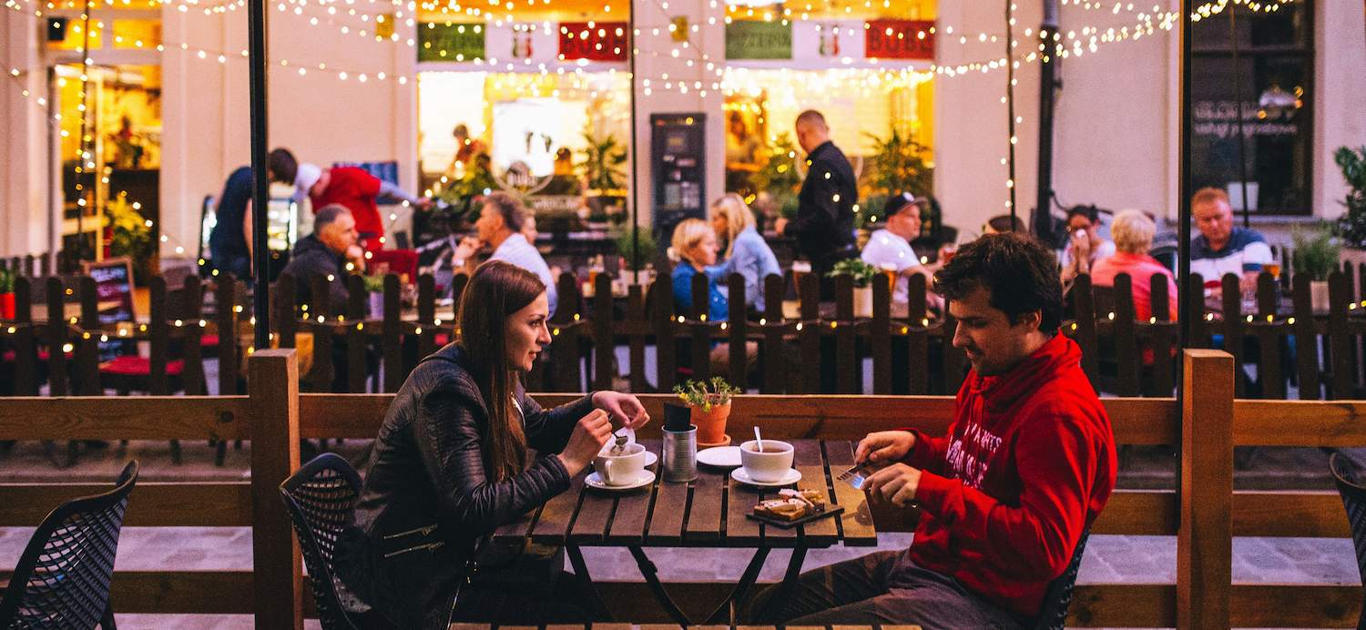 A man is eating with a woman at a restaurant trying to keep in mind some first date tips