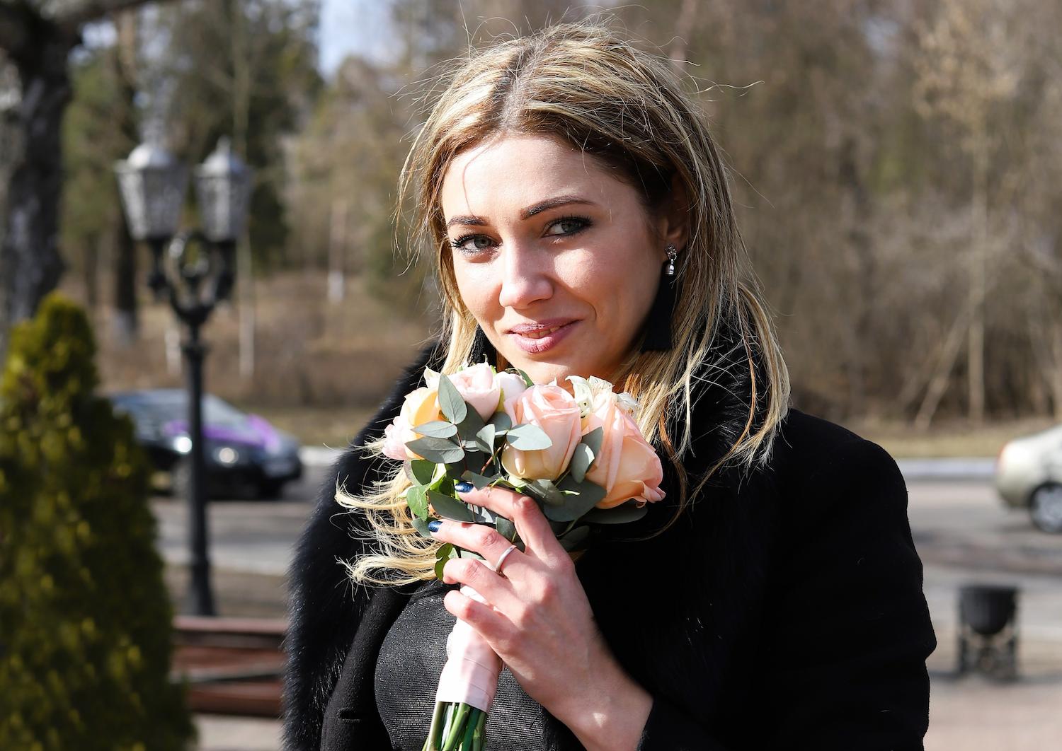 A Russian woman holding pink roses