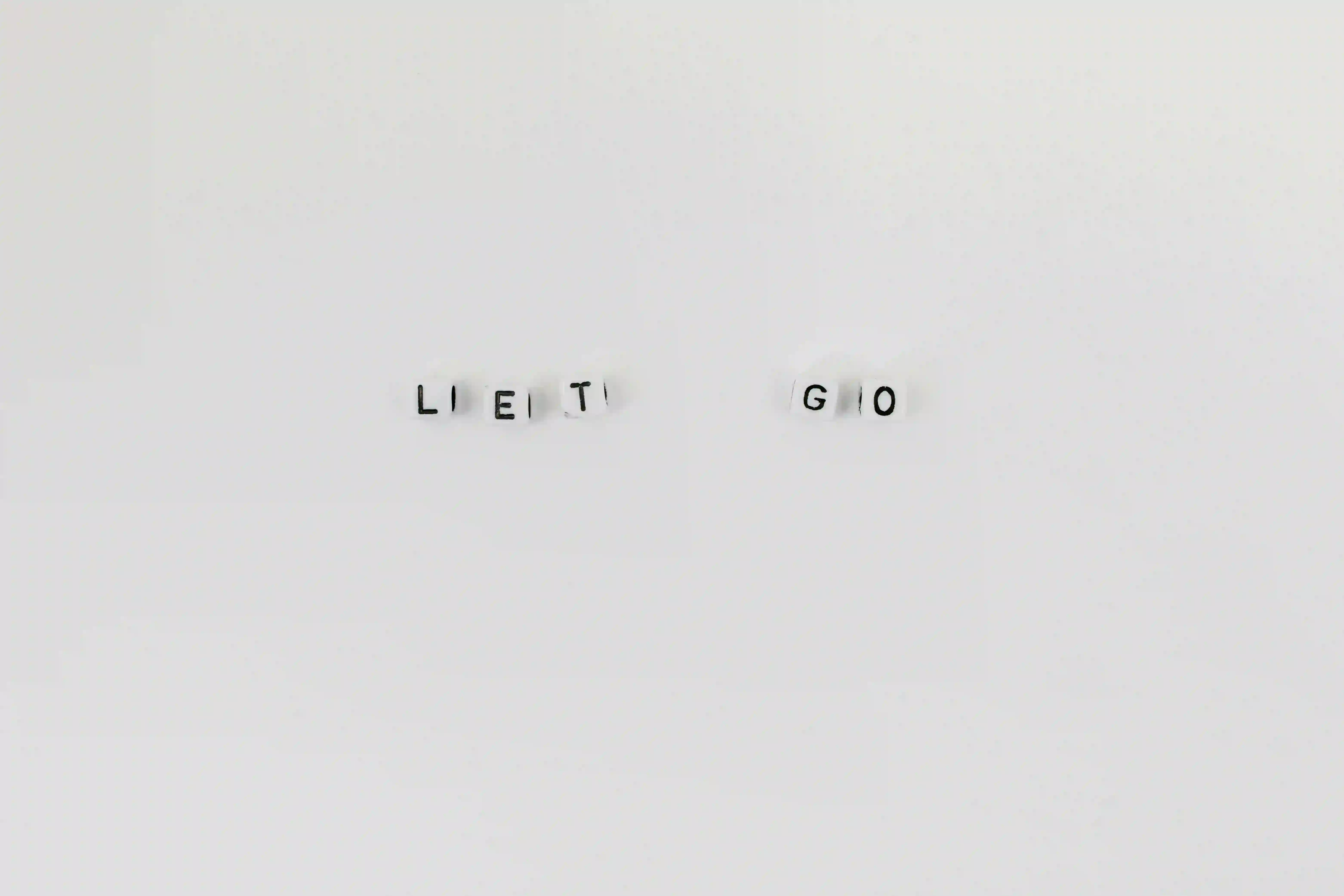 Dice spelling out “let go” on a flatlay