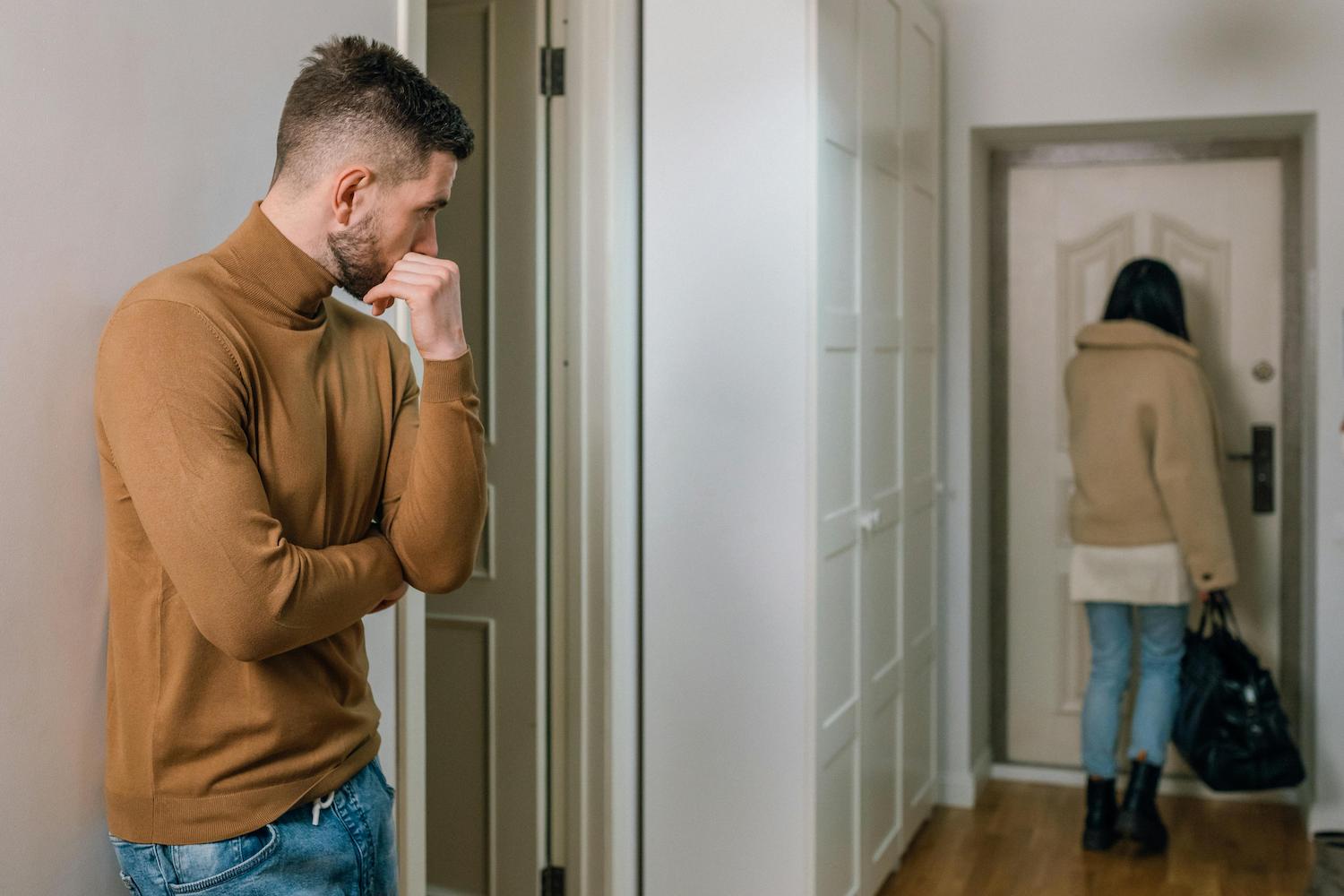 Woman walking out of a man’s house after a breakup