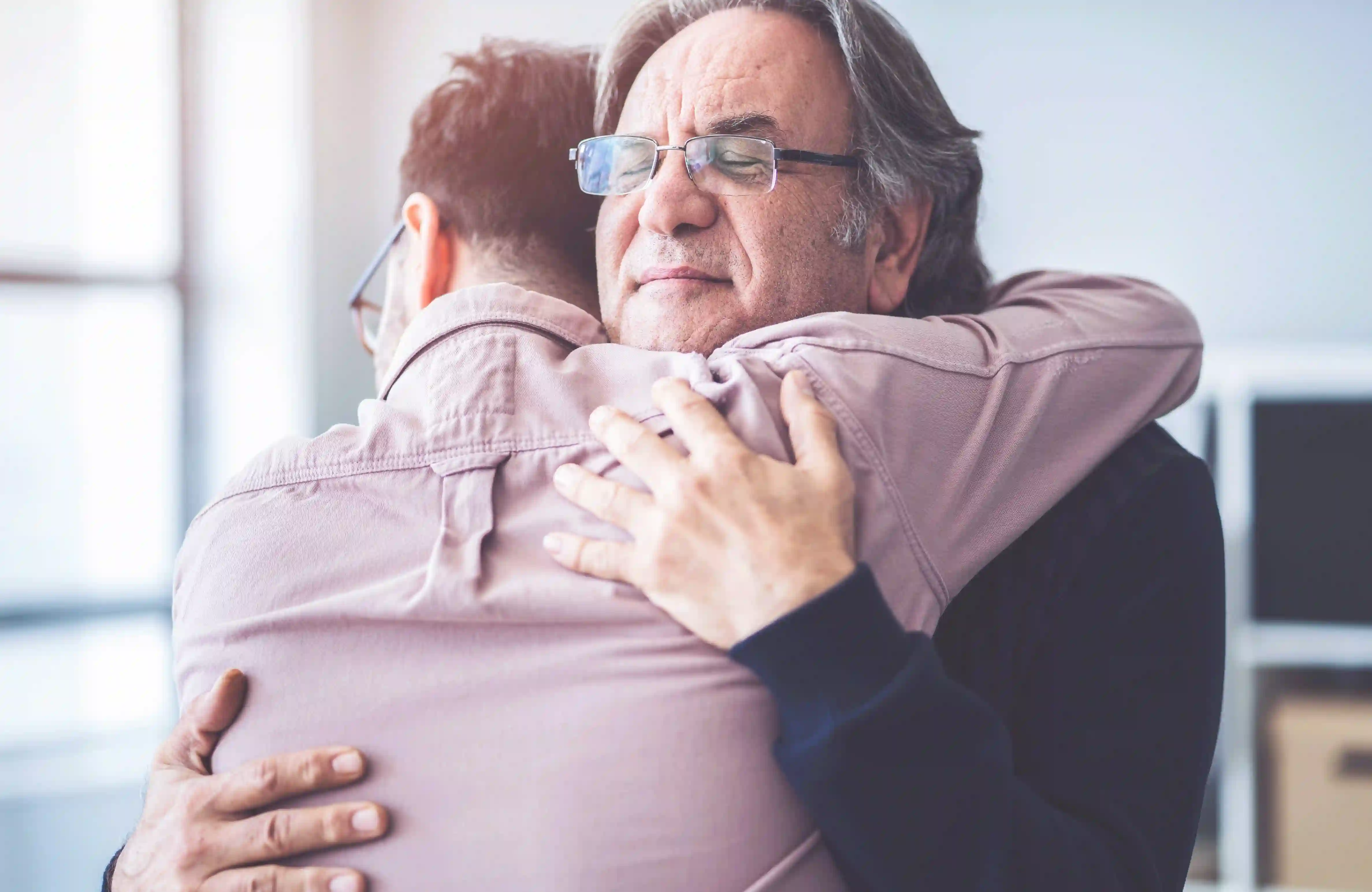 An older man hugging a younger one