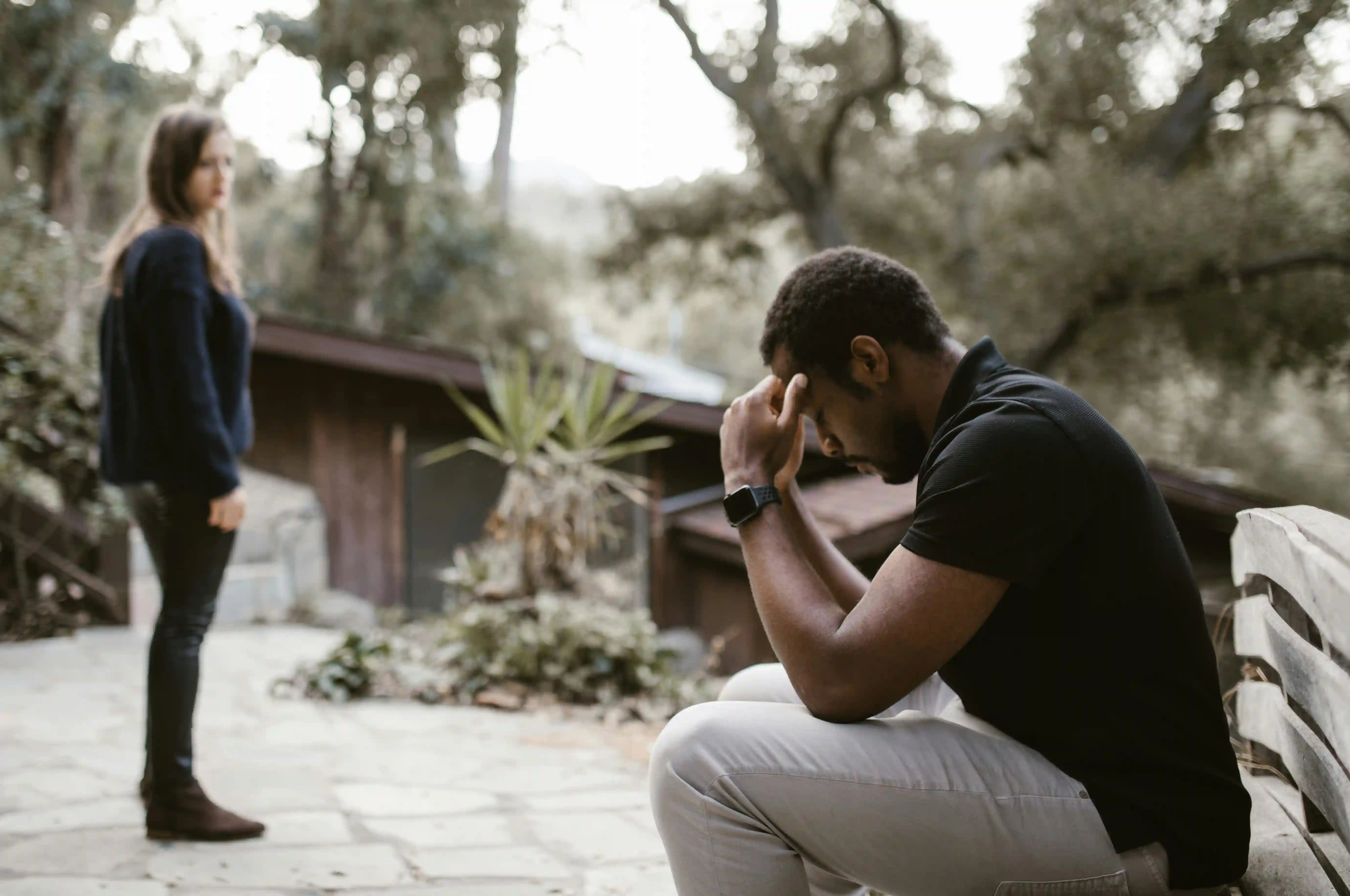 A man resting his forehead on his hands because he feels broken and unsure how to heal after a breakup