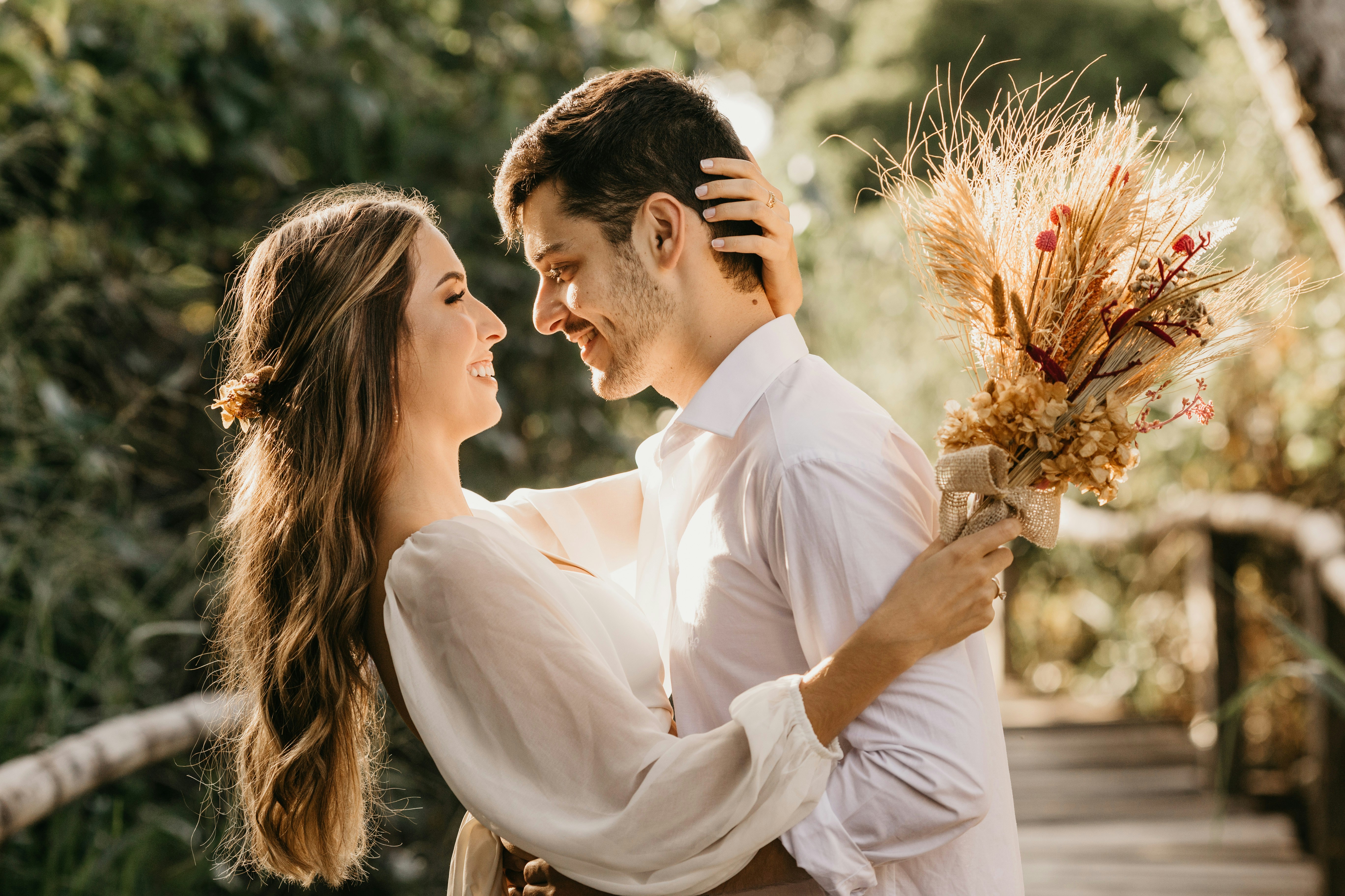A woman holding a bouquet and a man with their arms around each other.