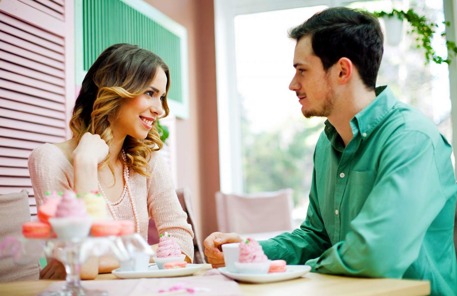 A man and a woman sitting on a table and smiling at each other