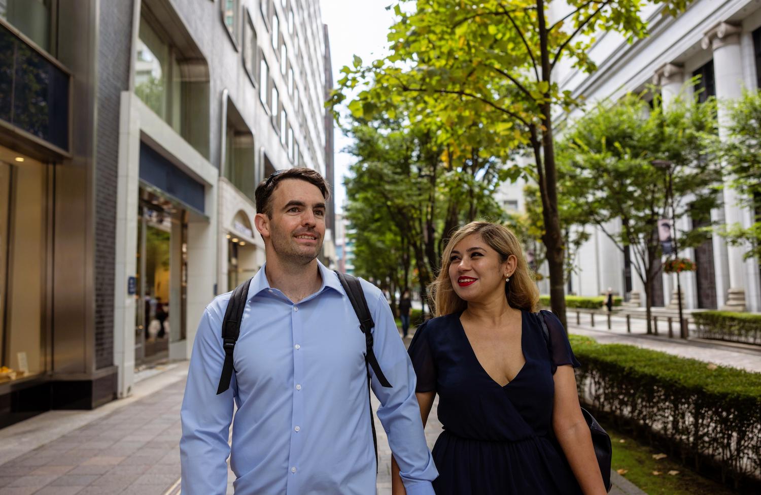 An interracial couple walking along the road.