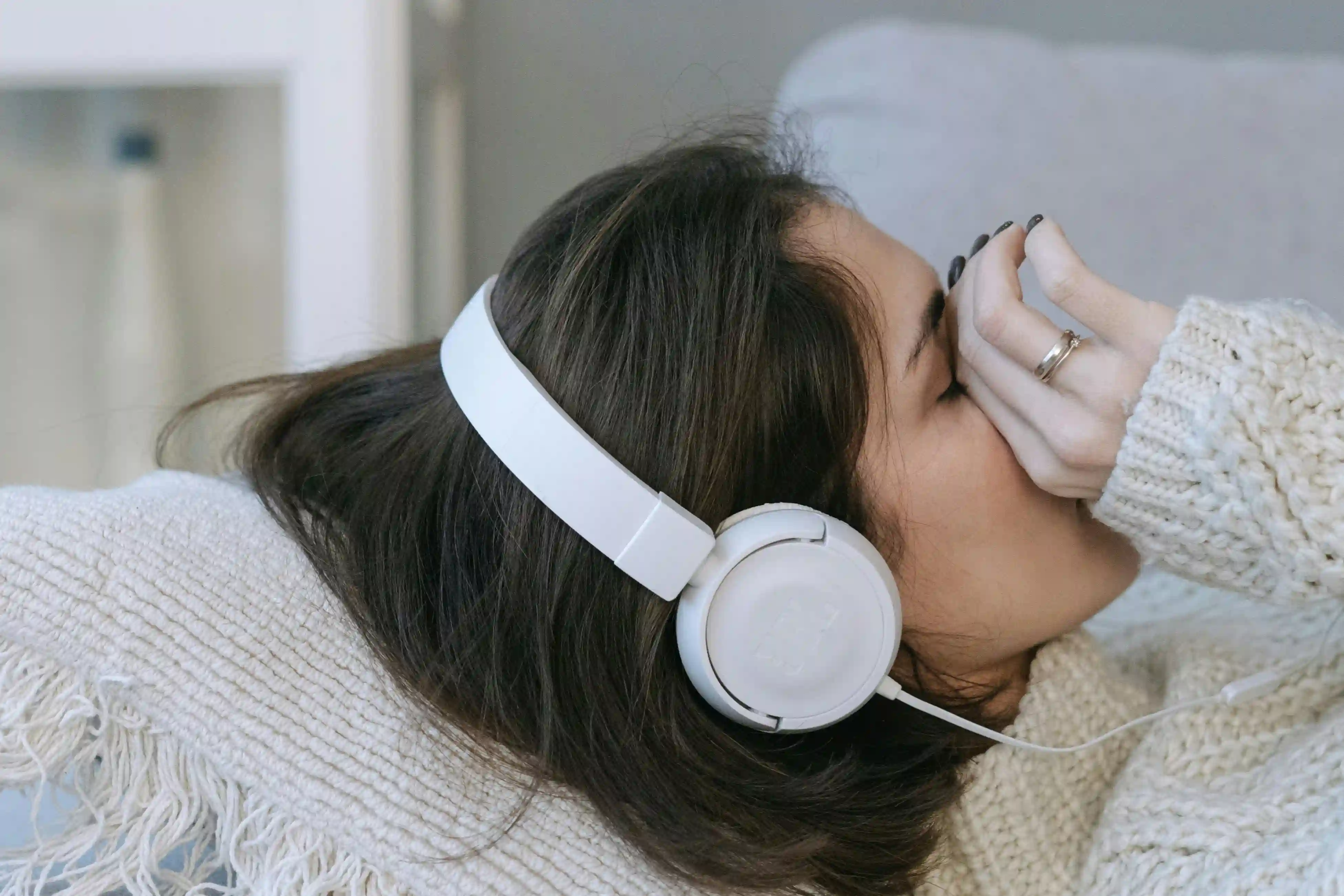 A girl wearing headphones almost crying from listening to music