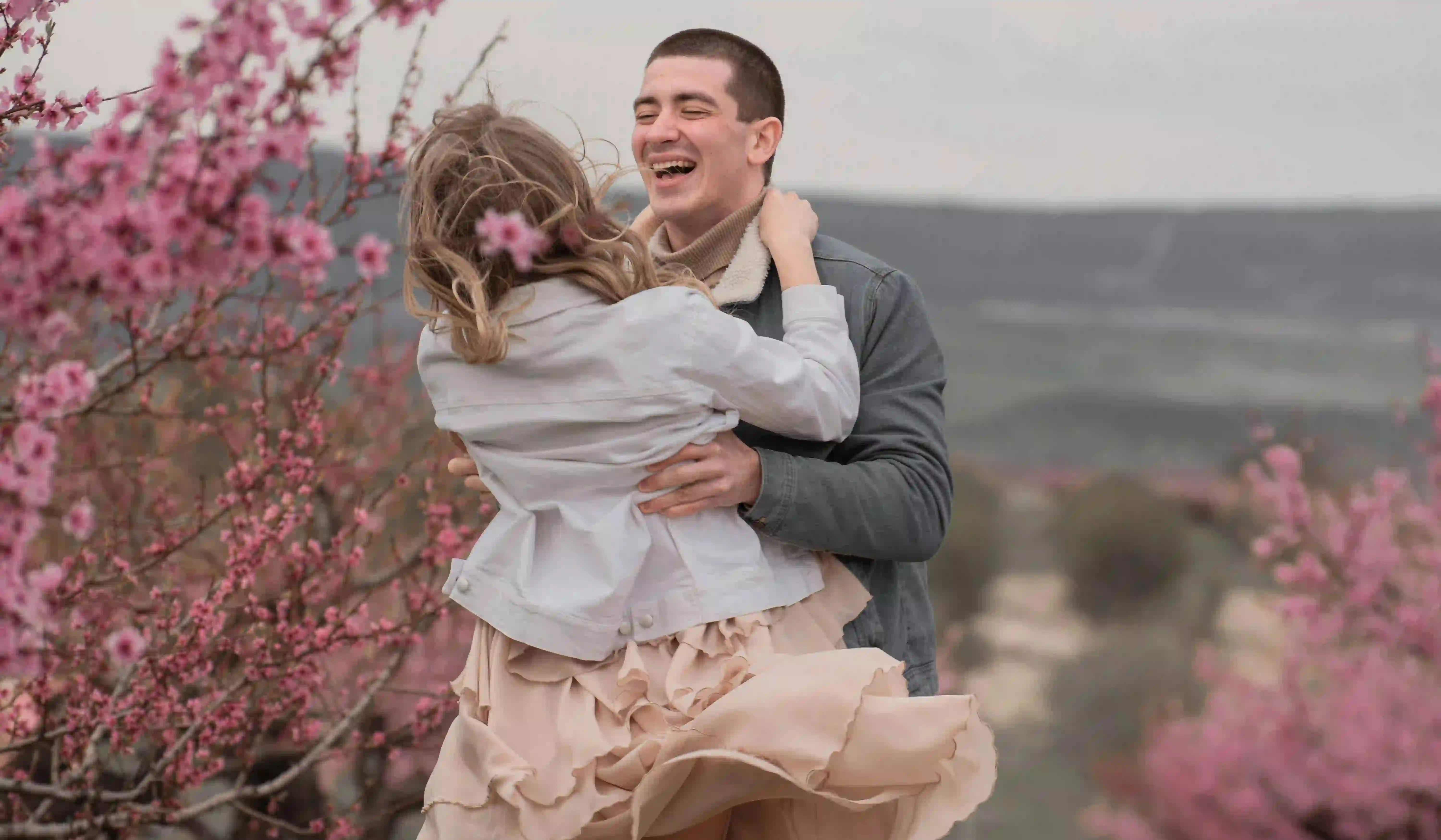 A couple hugging and laughing while visiting a botanical garden which is among the best choices on where to go on a first date